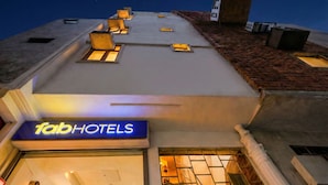 Un hotel con un cartel que dice "Tab Hotels" y varias ventanas en el piso superior.
