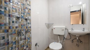 Un baño con inodoro, lavamanos y ducha.