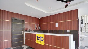 Una reception con una insegna 'fab hotels', una porta chiusa e un pavimento a scacchi.