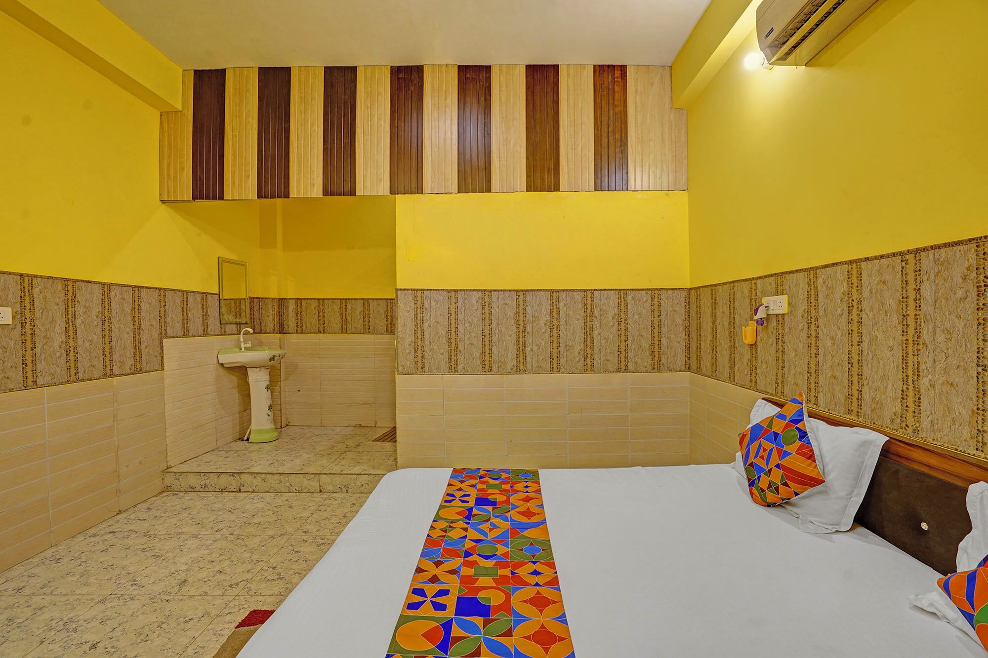 Una camera d'albergo con un letto, un bagno e una finestra.