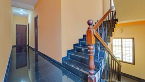 A staircase with black marble steps and a wooden handrail. - Via Fort Beach Residency (Kochi)
