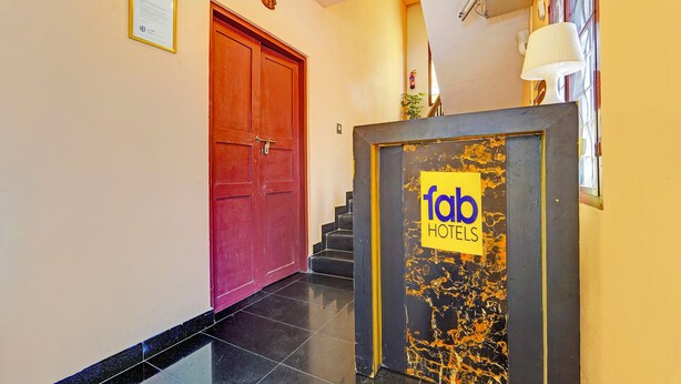 A hotel entrance with a red door, a sign for 'fob hotels', and a staircase leading to an upper floor. - Via Fort Beach Residency (Kochi)