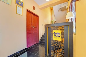 A hotel entrance with a red door, a sign for 'fob hotels', and a staircase leading to an upper floor. - Via Fort Beach Residency (Kochi)