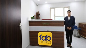 Ein Empfangsschalter mit einem Schild, auf dem 'fab hotels' steht, und einem 'rezeption'-Etikett.