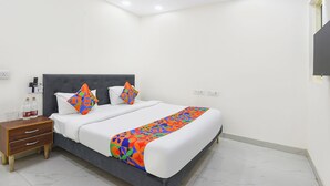 Ein modernes Hotelzimmer mit einem großen Bett, einem Nachttisch und einem Deckenventilator.