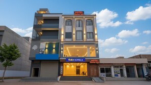 A hotel with a modern facade, a prominent entrance, and a sign indicating it is the Kesar Inn. - Fabhotel Kesar Inn (Jaipur)