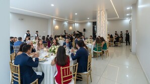 A formal dining room with round tables, guests seated, and a band performing. - Fabhotel Kesar Inn (Jaipur)