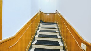 A wooden staircase with alternating black and white steps leading upwards. - Fabhotel Kochar Continental (New Delhi)