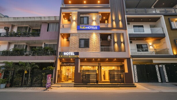 A modern hotel with a reception area, multiple floors, and balconies. - Fabhotel Kavish Villa (Indore)