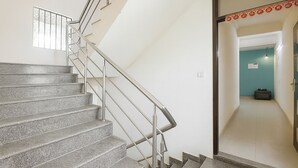 A staircase with metal railings leading to a door with a sign. - Via KD6 Plaza Residency (New Delhi)