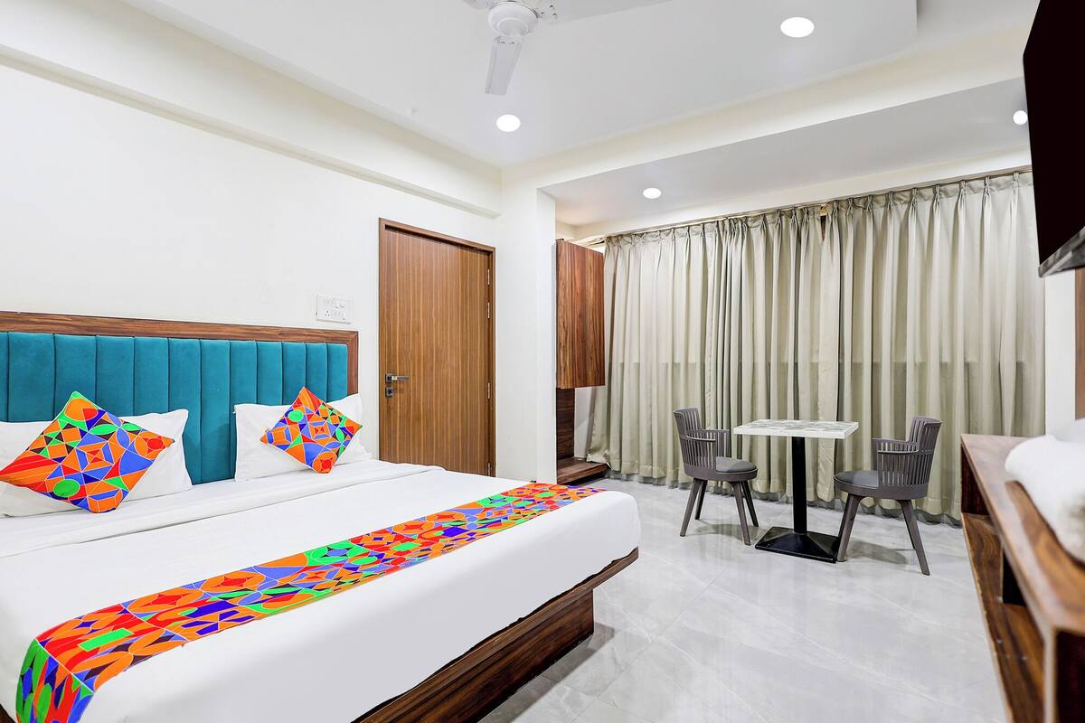 Una habitación de hotel con cama, escritorio y silla.