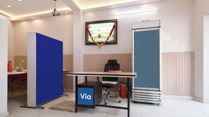 A modern office space with a desk, chair, and a 'Via' sign on the floor. - Via Kanha Palace (Ujjain)