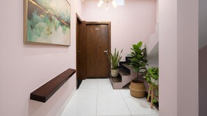 A hallway with a wooden door marked "901", a staircase, and a large abstract painting on the wall. - Via Kanha Palace (Ujjain)