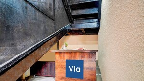 Un escalier avec une main courante en bois et une enseigne bleue portant l’inscription « Via » sur un comptoir en bois.