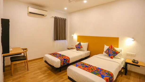 A hotel room with two beds, a desk, and a chair. - Fabhotel Sun Lodge (Pune)
