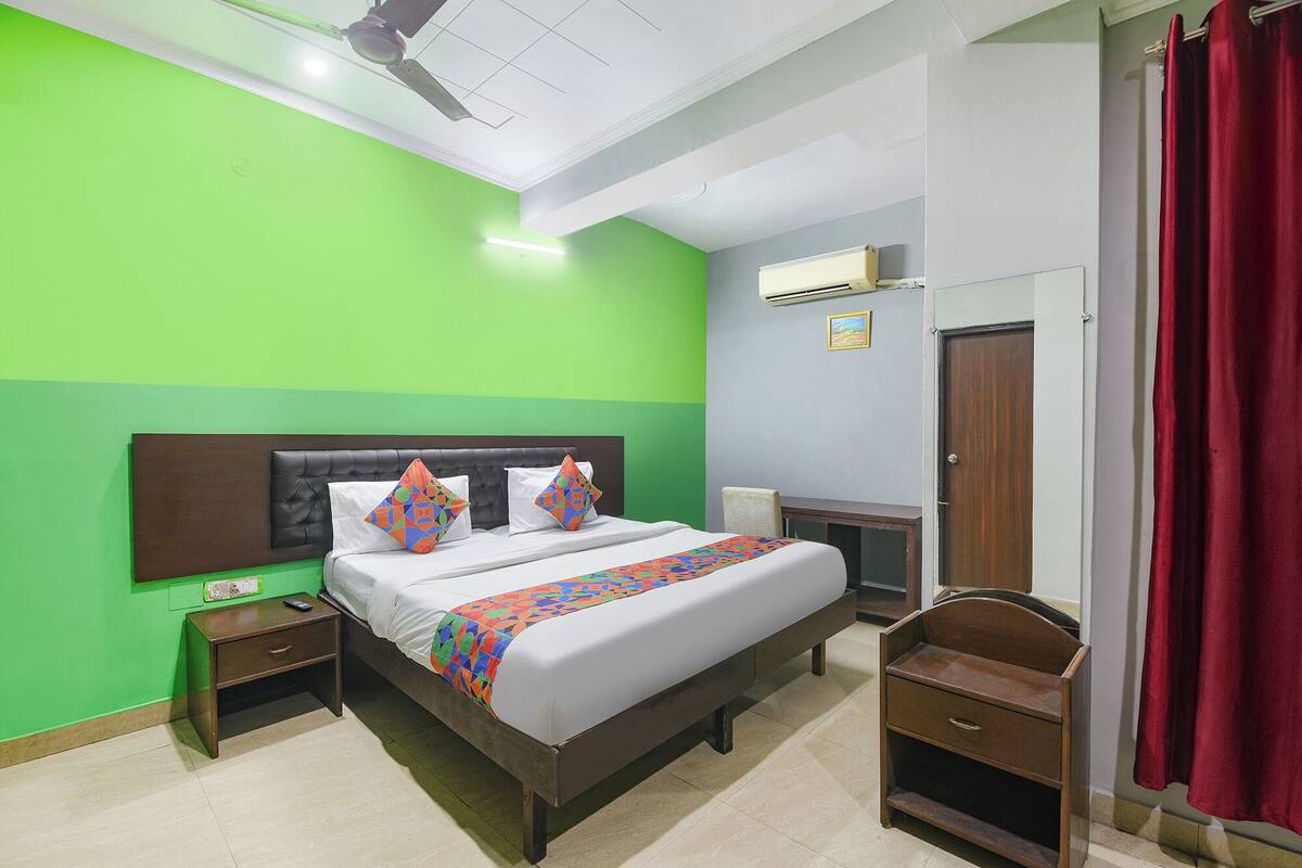 Une chambre à coucher avec un lit, une table de chevet, une chaise, une armoire et une porte.