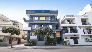 A modern hotel building with a 'Via' sign, a reception area, and multiple balconies. - Via Elite Stay (Gurugram)