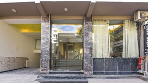 A hotel entrance with marble steps and a glass door. - Fabhotel Dev Residency (New Delhi)