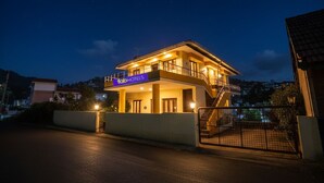 A two-story building with a sign reading "Tab Hotels." It features a balcony on the upper floor and a staircase leading to the entrance. - Via Yellow Mist Home Stay (Kodaikanal)