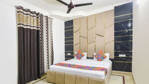 A bedroom with a bed, a ceiling fan, and a window with curtains. - Fabhotel Sweet Inn (New Delhi)