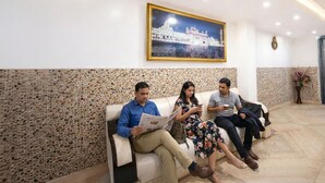 A reception area with a seating area, a framed picture of a building, and a decorative wall. - Fabhotel Sweet Inn (New Delhi)