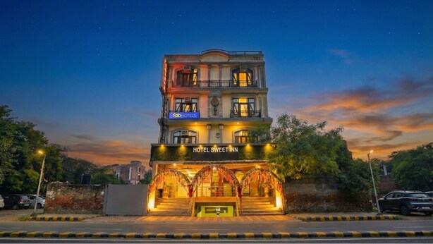 A multi-story hotel with a prominent entrance, a sign for 'HOTEL SWEET INN', and a 'fabHOTELS' sign above the entrance. - Fabhotel Sweet Inn (New Delhi)