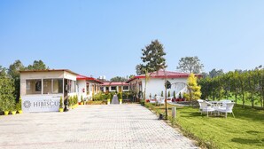 A resort with multiple buildings, paved pathways, and outdoor seating areas. - Fabhotel Wild Hibiscus Resort (Ramnagar)