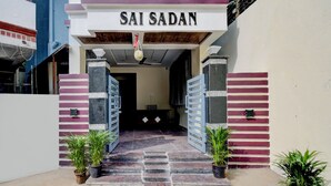 The entrance to Sai Sadan with a sign above the door, a staircase leading up, and potted plants at the base. - Fabhotel Heaven 75 (Hyderabad)