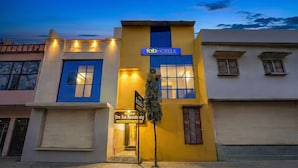 A hotel with a yellow facade, a sign for 'Fab Hotels', and a sign for 'Omishach Sai Residency'. - Fabhotel Om Sai Residency (Varanasi)