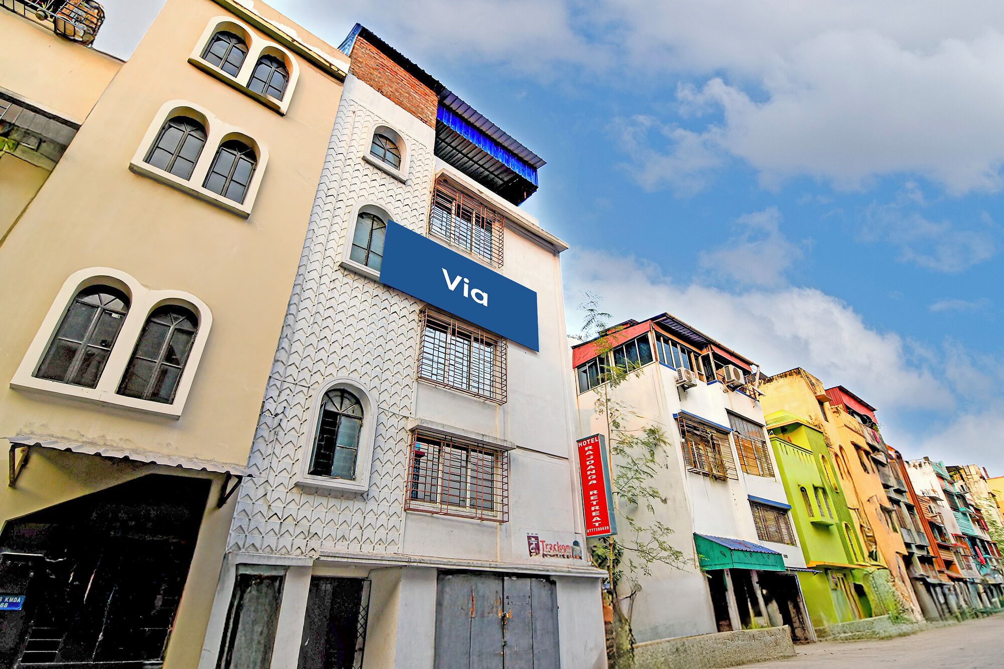 A multi-story building with a prominent 'Via' sign, a visible staircase, and a 'HOTEL' sign.