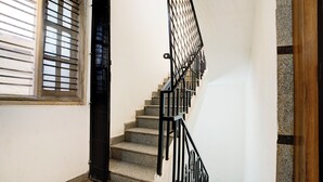 A staircase with black railings leading to an upper floor. - FabHotel Purple Grand - Jalahalli West (Bangalore)
