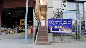 A hotel entrance with a sign for 'Purple Grand Deluxe Rooms' on the 1st floor. - FabHotel Purple Grand - Jalahalli West (Bangalore)