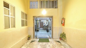 A hallway with a marble floor, a reception desk, and a fire extinguisher. - Via Mansagar (Jaipur)