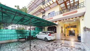 A covered parking area with a white car parked inside. - Via Mansagar (Jaipur)