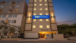 A multi-story hotel with a prominent 'fabHOTELS' sign, a 'SUIVAM CLASSIC' label, and a well-lit entrance. - FabHotel Honey Grand - 400m From Yashoda Hospitals, Hitech City. (Hyderabad)