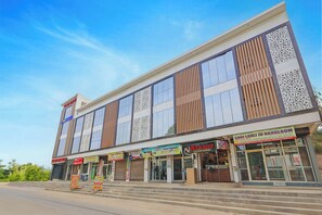 Un immeuble commercial à plusieurs étages, doté de différentes boutiques, dont un magasin de jus et de boissons.