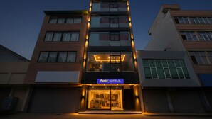 A multi-story hotel with a modern facade, featuring a prominent 'fabHOTELS' sign at the entrance. - Fabhotel Happy Stay (Noida)