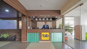 Zona de recepció amb un taulell de fusta, un rellotge i un cartell de 'fab hotels'.