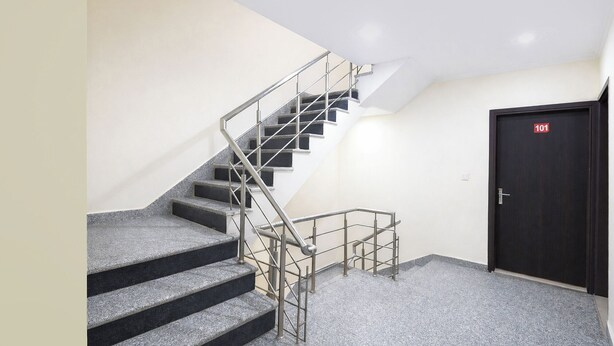 A staircase with metal railings leading to a dark door marked with the number 101. - Via BD Palace (New Delhi)