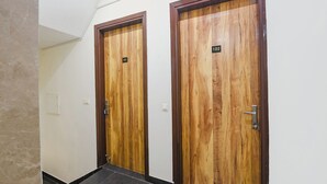 Two wooden doors with numbers 101 and 102, indicating room numbers. - Fabhotel Ostan Stayz (Gurugram)