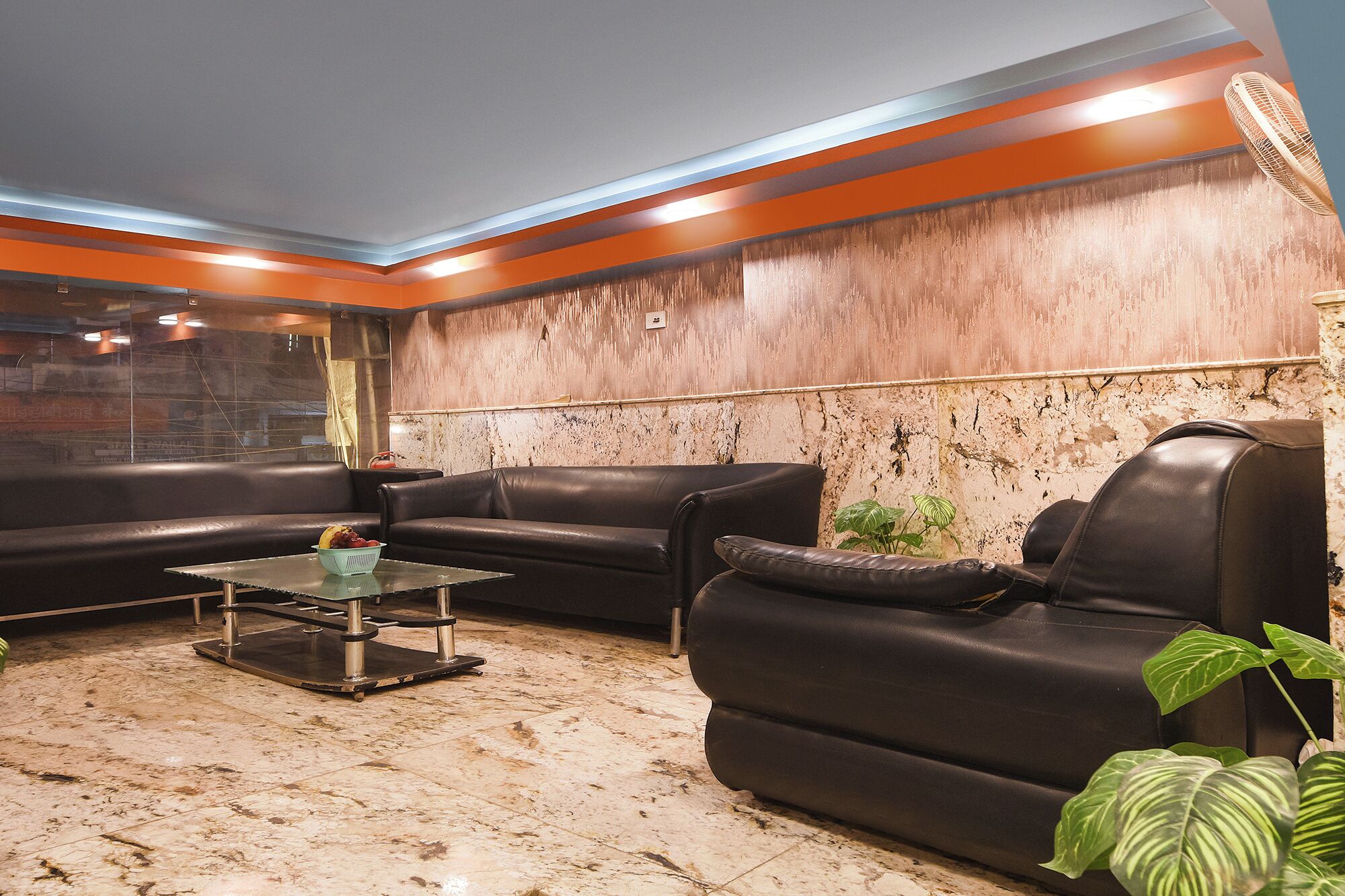 Un salón moderno con sofás de cuero, una mesa de centro de vidrio y una decoración de pared.