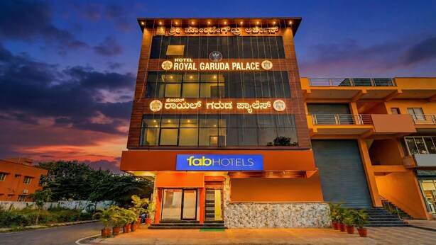 A hotel named 'Royal Garuda Palace' with a sign in multiple languages, including English and a local script. - Fabhotel Royal Garuda Palace (Ramanagara)