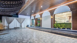 Un espacio interior amplio con suelo estampado, un banco de asientos y una ventana que ofrece vistas a zonas verdes.