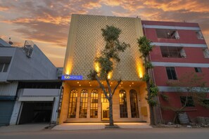 A building with a sign for 'FabHotels' and a tree in front. - Fabhotel Saraca Inn (Indore)