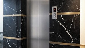 An elevator with marble walls and a digital display showing the number 2. - Fabhotel Blu Mark (Indore)
