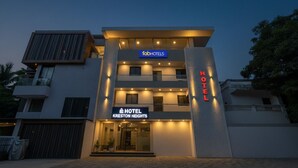 Un hôtel moderne doté d’une entrée imposante, de plusieurs étages et d’une façade bien éclairée.
