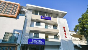Un hôtel dont la façade porte une enseigne indiquant « Tab Hotels » et « Kreston Heights ».