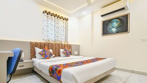 Une chambre d’hôtel avec un lit, un bureau et une chaise.