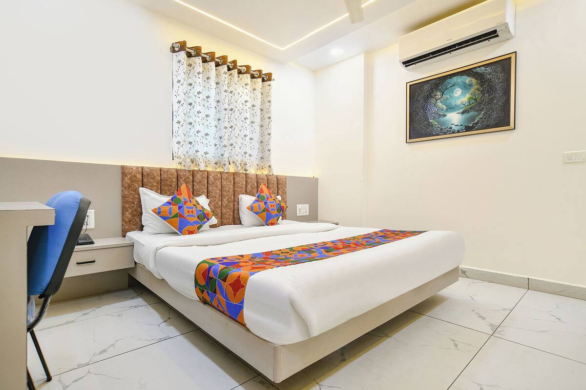 A hotel room with a bed, a desk, and a chair.