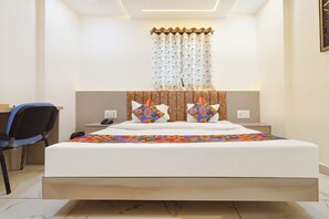A hotel room with a bed, two bedside tables, a chair, and a window with curtains. - Fabhotel Kreston Heights (Indore)